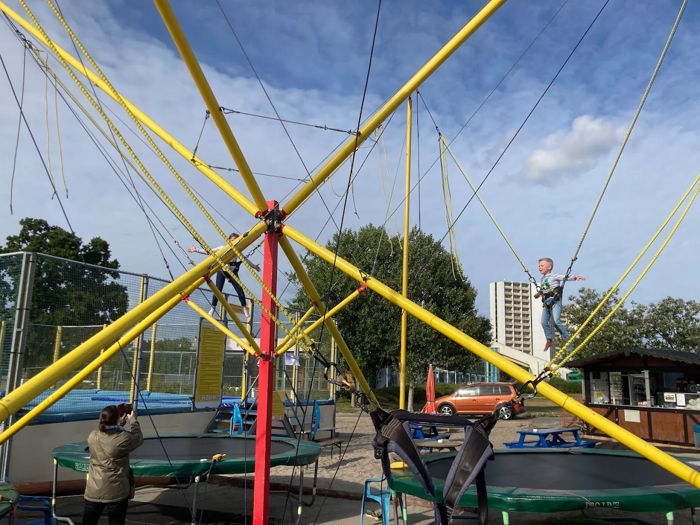 Kinder fliegen am gelben Bungee-Trampolin